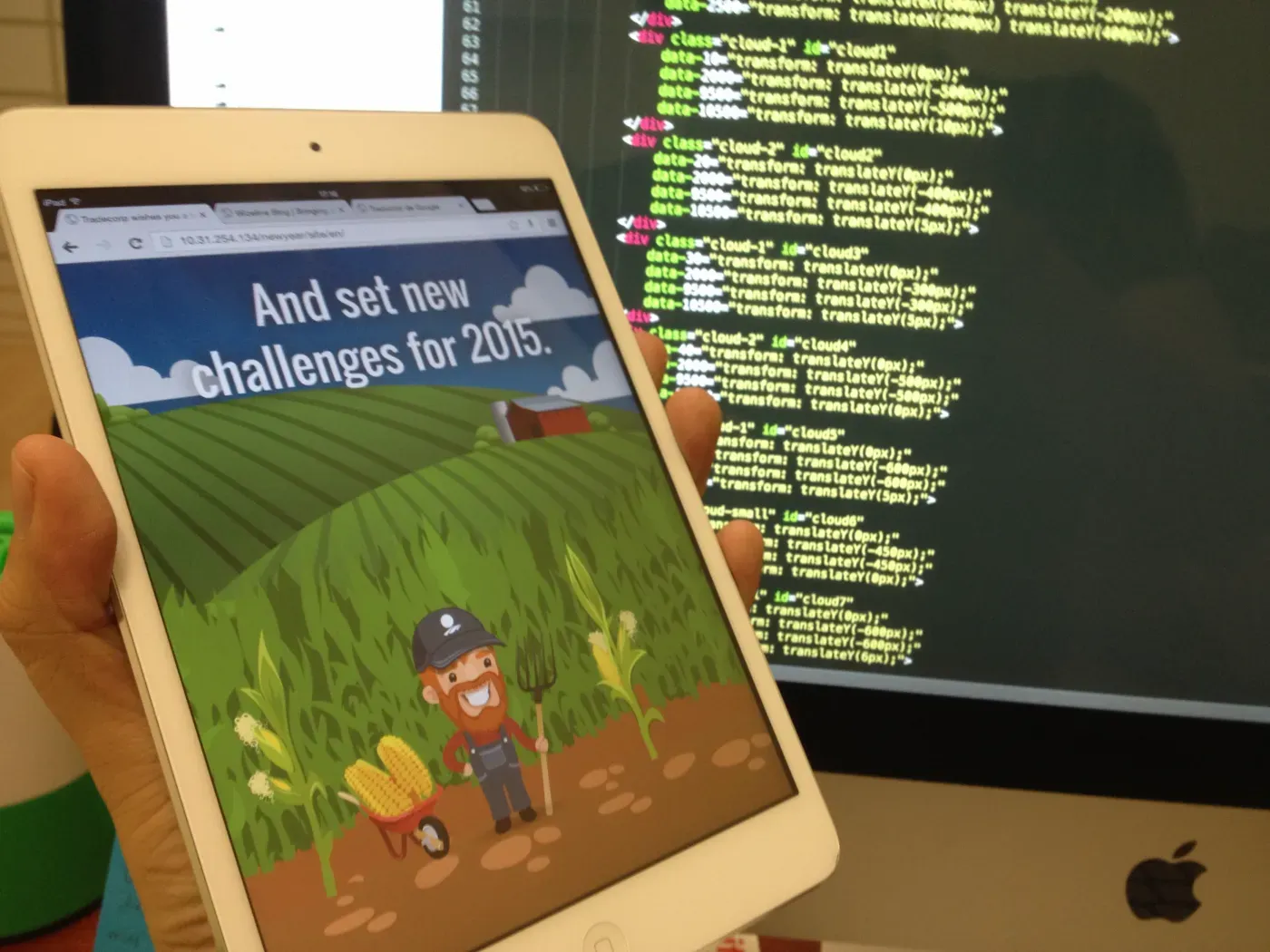 An illustrated seasonal web page on a tablet, its parallax code behind it.