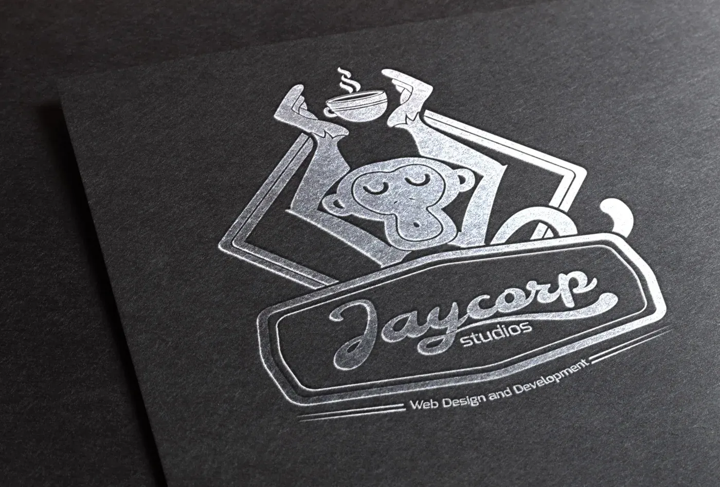 A silver stamped Jaycorp Studios mark on dark paper.