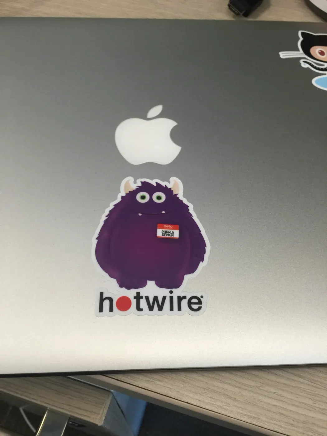 A Hotwire sticker on the lid of a work laptop.